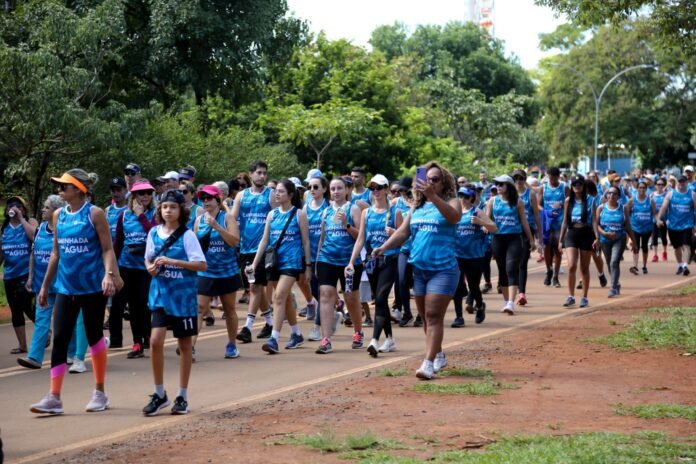 Caminhada-Capa Grupo de pessoas participando da Caminhada da Água no Parque Sarah Kubitschek, promovida pela Adasa e Caesb, celebrando o Dia Mundial da Água.