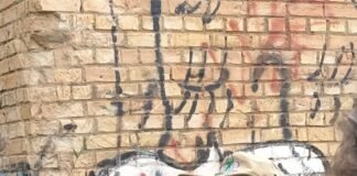 Grupo de escoteiros e moradores reunidos em frente a mural histórico na Candangolândia durante a Trilha Pirá-Brasília.